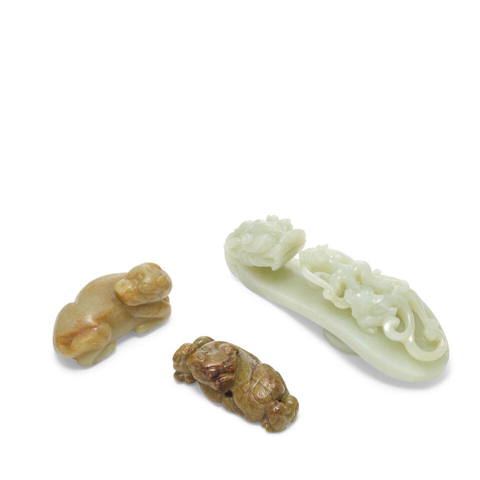 THREE JADE CARVINGS Qing dynasty and later (3): THREE JADE CARVINGS Qing dynasty and later Including two carved animal models: a recumbent ox and a lion dog group; and a 'dragon' belt hook. 2 1/8in (5.4cm); 2 1/4in (5.7cm); 4 3/8in (11.2cm) long (3