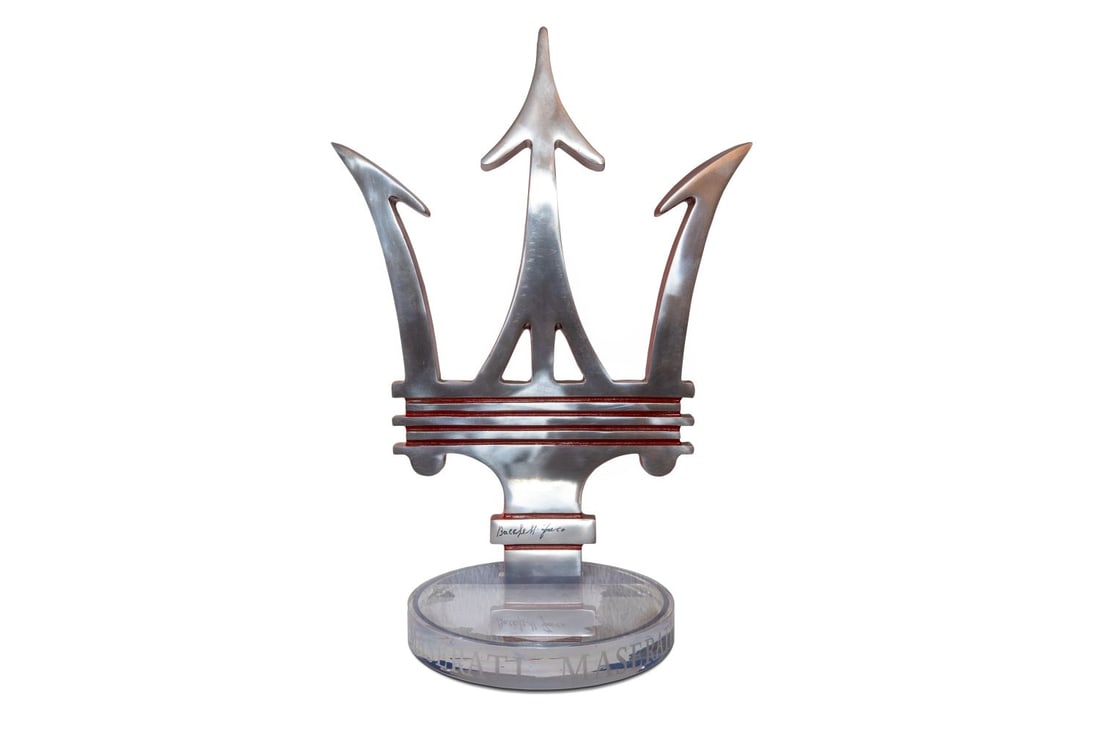 Maserati Logo - Trident: Maserati Logo - Trident Maserati brand logo featuring the iconic trident. Aluminium trident mounted on a plexiglass base. Signed at the bottom by Franco Bacchelli. Dimensions: 53 × 38 cm Accompan