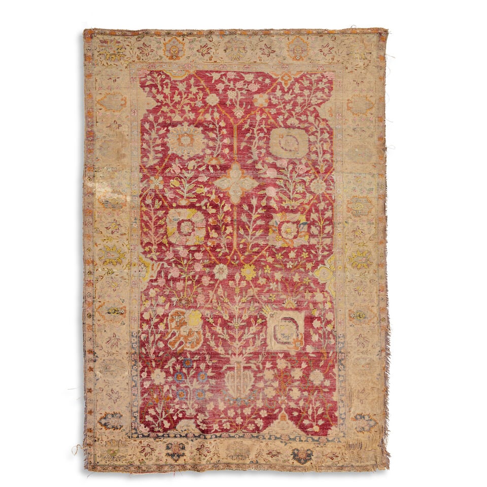 A Mahal style silk rug 19th century 189cm x 132cm: A Mahal style silk rug 19th century The field with Shah Abbas palmettes, pomegranates and foliage in saffron and yellows on a red ground, within a wide palmette triple border, distressed condition.