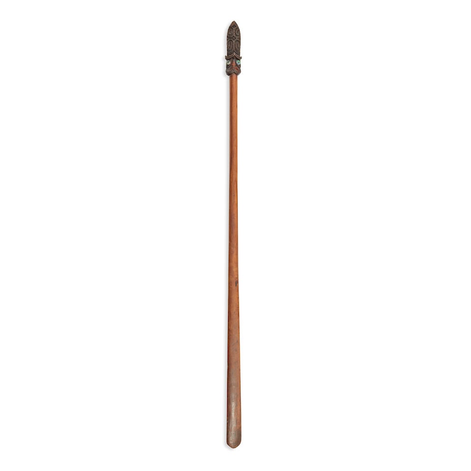 A Maori wood quarter staff, Taiaha: A Maori wood quarter staff, Taiaha Of spatulate form, the finial carved with a janus head, having abalone eyes, the extended tongue carved with notched scrolls, good patina. 141cm long Footnotes: Prov