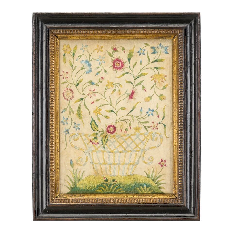 An 18th century silk embroidery of flowers within a twin-handled basket: An 18th century silk embroidery of flowers within a twin-handled basket On a naturalistic base mounted in an ebonised frame, measurements including frame: 21cm wide, 2cm deep, 26cm high (8in wide, 0 1