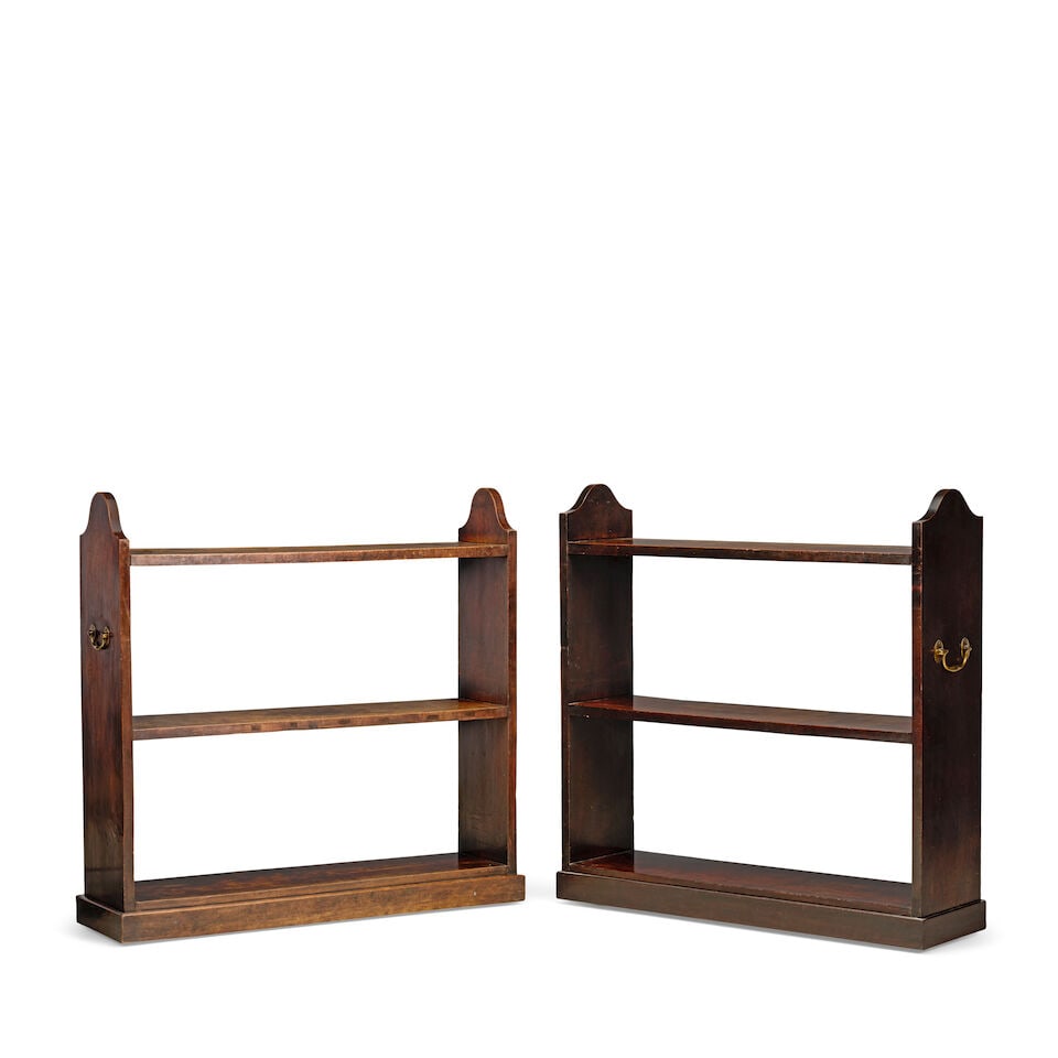 A near pair of mahogany open sided museum shelves 19th century and later (2): A near pair of mahogany open sided museum shelves 19th century and later With arched ends and brass carrying handles flanking three open shelves on a plinth base with wooden castors, 115cm wide x