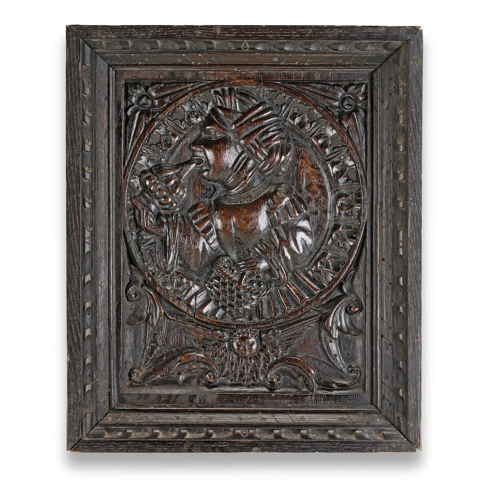A carved oak panel of jollity Flemish, late 16th century: A carved oak panel of jollity Flemish, late 16th century The panel carved with a lady drinking in profile, 44cm wide, 7cm deep, 53cm high (17in wide, 2 1/2in deep, 20 1/2in high) For further