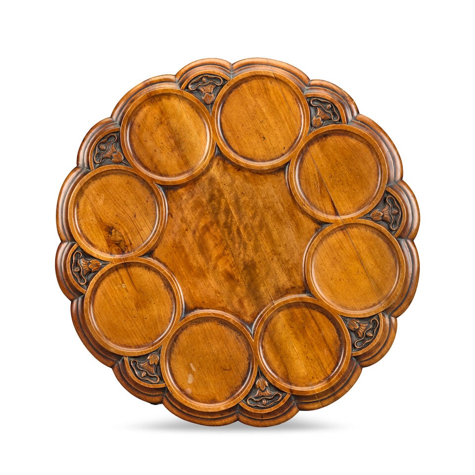 A Victorian carved and turned mahogany Lazy SusanAfter a design by William Harrison: A Victorian carved and turned mahogany Lazy Susan After a design by William Harrison The shaped circular top with eight moulded circular recesses separated by spandrels each containing a bell flower,