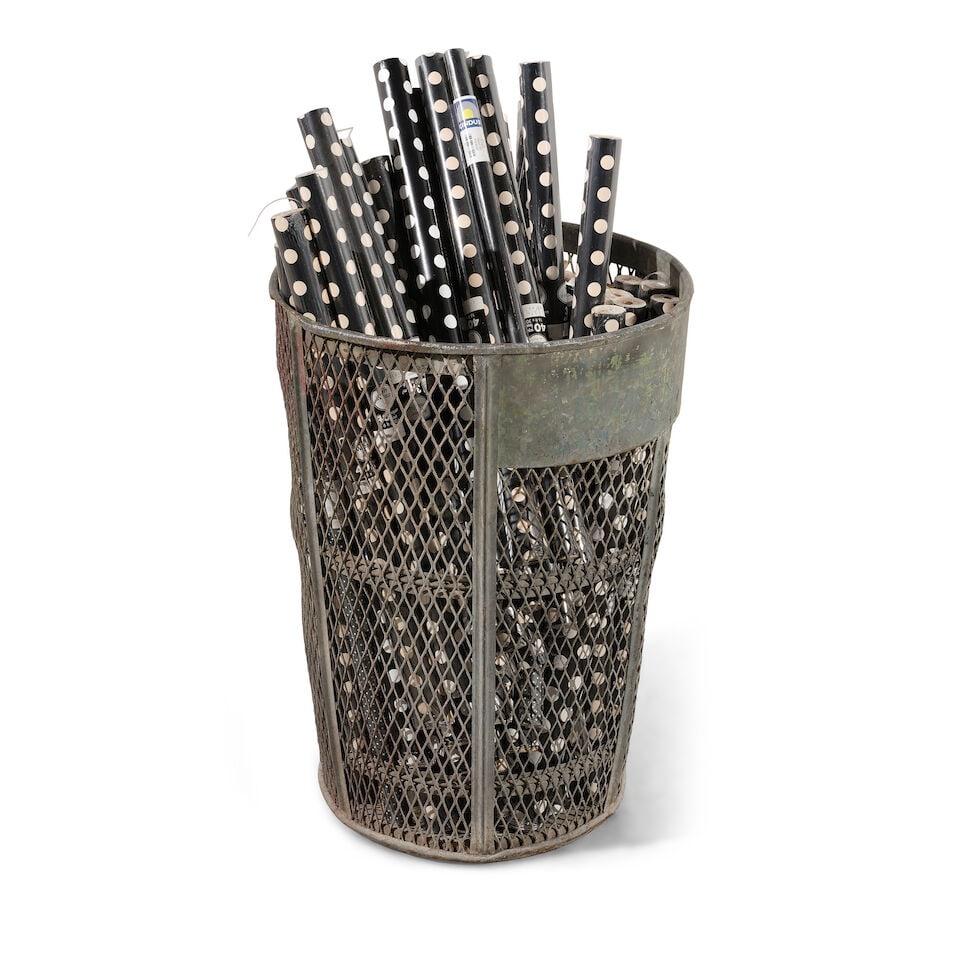 A LARGE INDUSTRIAL PIERCED METAL BASKET FILLED WITH BLACK AND WHITE WRAPPING PAPER: A LARGE INDUSTRIAL PIERCED METAL BASKET FILLED WITH BLACK AND WHITE WRAPPING PAPER height of basket 33in; diameter 24in Footnotes: From Diane Keaton's studio office in her Sullivan Canyon home. This l