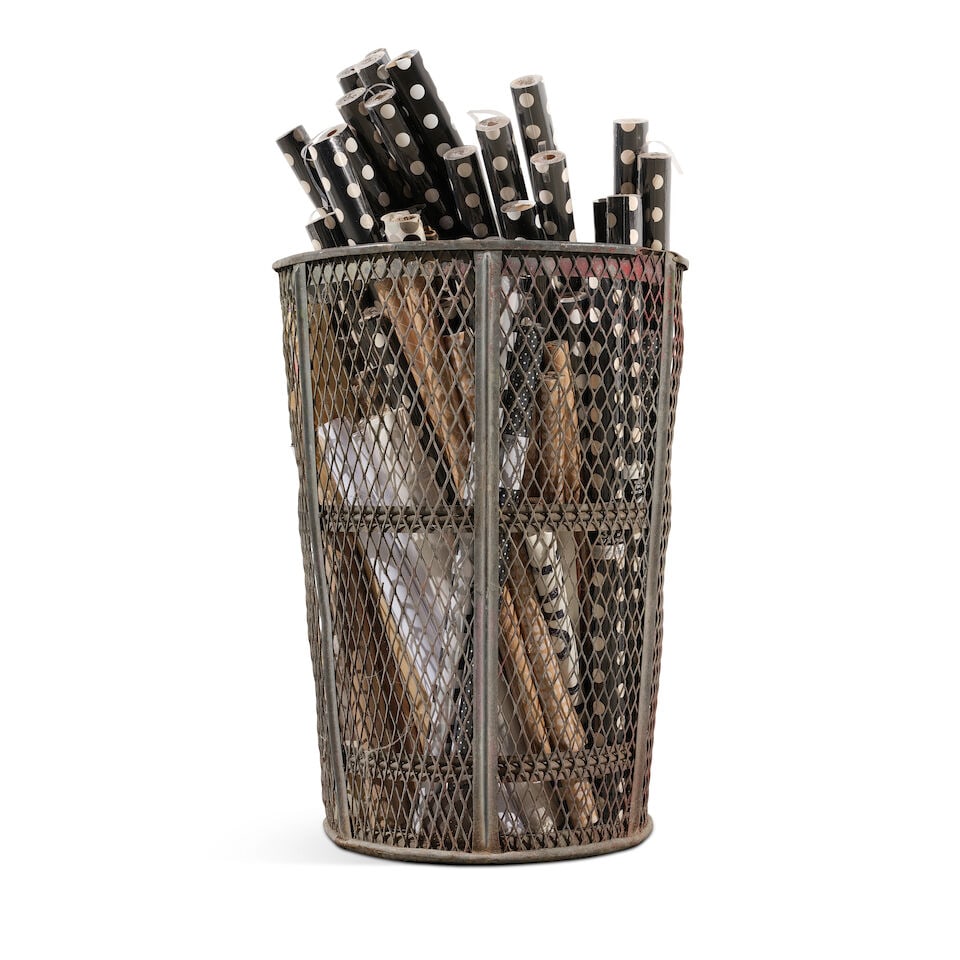 A LARGE INDUSTRIAL PIERCED METAL BASKET FILLED WITH BLACK AND WHITE WRAPPING PAPER - 2
