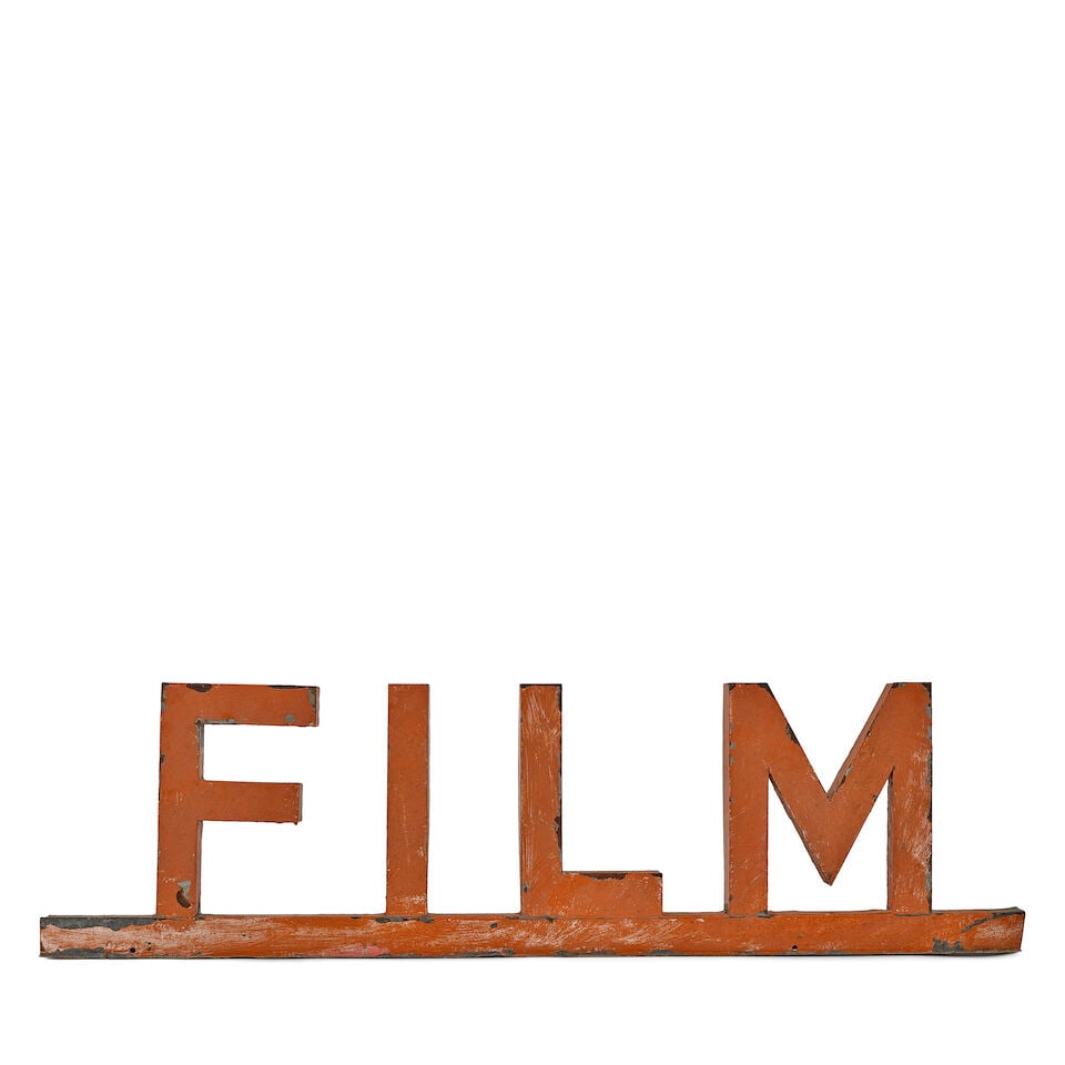 AN ORANGE PAINTED METAL FILM SIGN: AN ORANGE PAINTED METAL FILM SIGN height 14 1/4in; width 51 1/2in; depth 2 1/2in Footnotes: From Diane Keaton's studio office in her Sullivan Canyon home. This lot is subject to the following lot