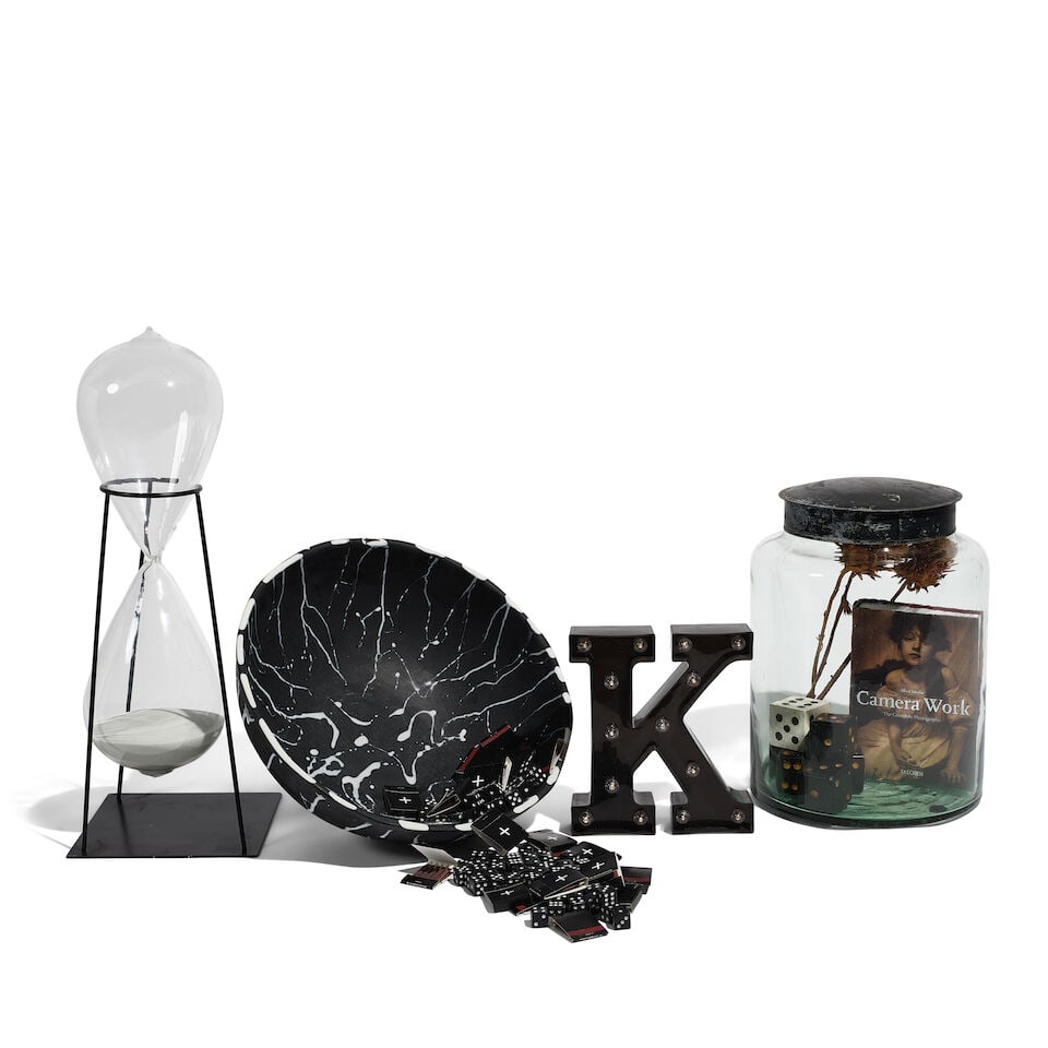 A GROUP OF BLACK AND WHITE KITCHEN DECORATIONS: A GROUP OF BLACK AND WHITE KITCHEN DECORATIONS Comprising a large glass jar filled with dice, a book, and dried flowers, a metal mounted hourglass, a plastic letter K, and a bowl filled with dice and