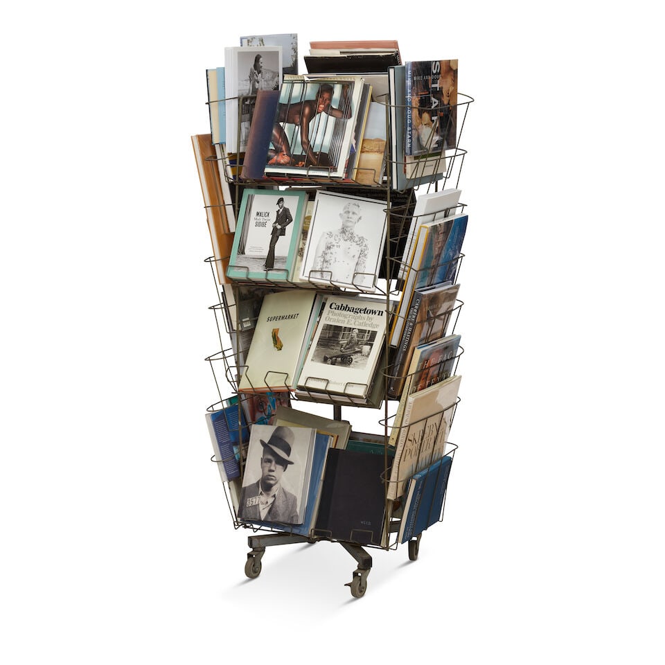 AN INDUSTRIAL METAL RACK CURATED WITH BOOKS, MAGAZINES, AND OBJECTS - 2