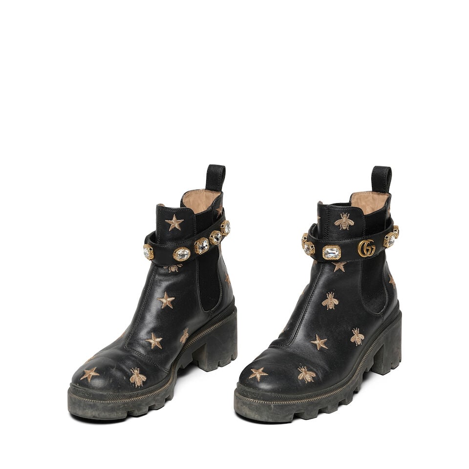 A PAIR OF GUCCI GOLD BEE AND STAR EMBROIDERED BLACK CALFSKIN LEATHER ANKLE BOOTS: A PAIR OF GUCCI GOLD BEE AND STAR EMBROIDERED BLACK CALFSKIN LEATHER ANKLE BOOTS Marked size 40 1/2in. Footnotes: Literature Keaton, Diane. Fashion First. Rizzoli, New York, 2024 (without