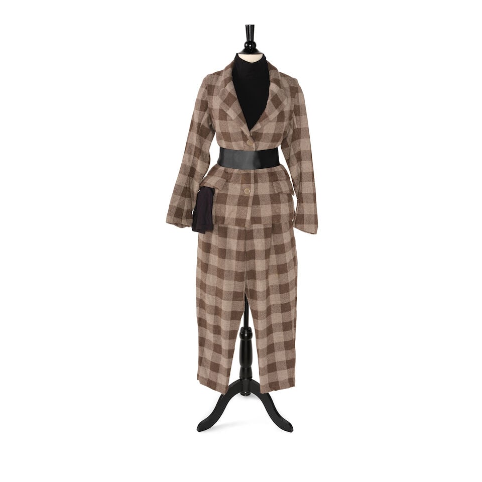 A BROWN AND CREAM PLAID SUIT: A BROWN AND CREAM PLAID SUIT Comprising a pair of cropped pants with an interior drawstring and jacket with no labels or marked sizes, together with a black turtleneck and black arm