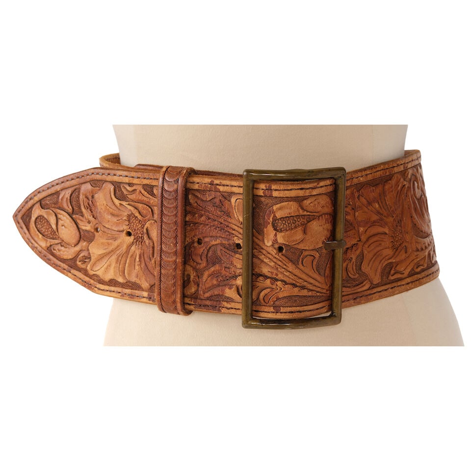 AN EMBOSSED AND CHASSED BROWN LEATHER FLORAL WIDE BELT: AN EMBOSSED AND CHASSED BROWN LEATHER FLORAL WIDE BELT With brass-toned hardware, no marked size. length 37in Footnotes: Keaton, Diane. Fashion First. Rizzoli, New York, 2024. This lot is subject to t