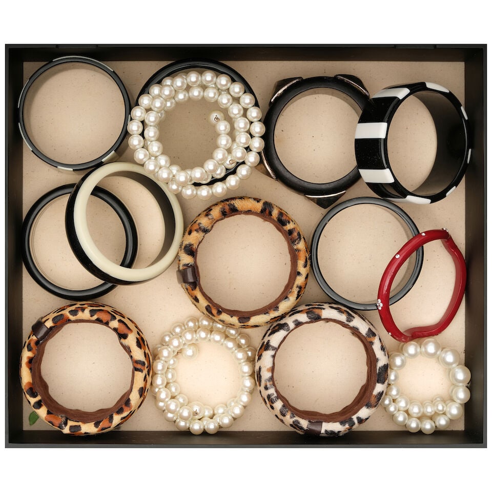 A CURATED BOX OF CUFFS AND BANGLES: A CURATED BOX OF CUFFS AND BANGLES Including faux pearl examples, leopard print examples, and black and white striped examples. height of box 4in; width 14in; depth 12in This lot is subject to the