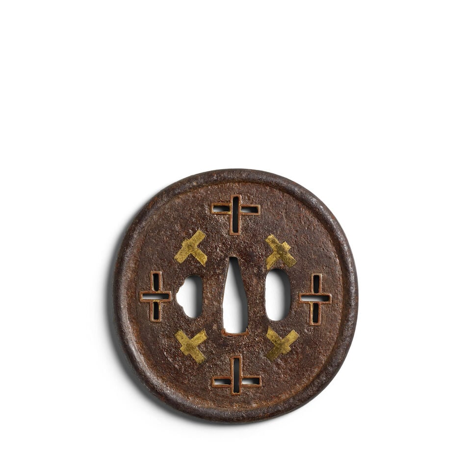 AN IRON NAMBAN SUKASHI TSUBA Momoyama (1573-1615) or Edo (1615-1868) period, late 16th/17th century: AN IRON NAMBAN SUKASHI TSUBA Momoyama (1573-1615) or Edo (1615-1868) period, late 16th/17th century The almost circular tsuba with a raised and rounded rim, four cross-shaped piercings lined with a co