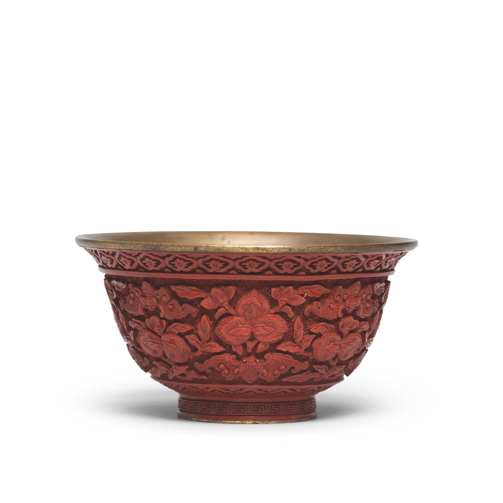 A CINNABAR LACQUER 'BAT AND PEACHES' BOWL Qianlong: A CINNABAR LACQUER 'BAT AND PEACHES' BOWL Qianlong Lacquered around a metal body and deeply carved around the exterior with a wide band of alternating clusters of ripe peaches borne on leafy gnarled b
