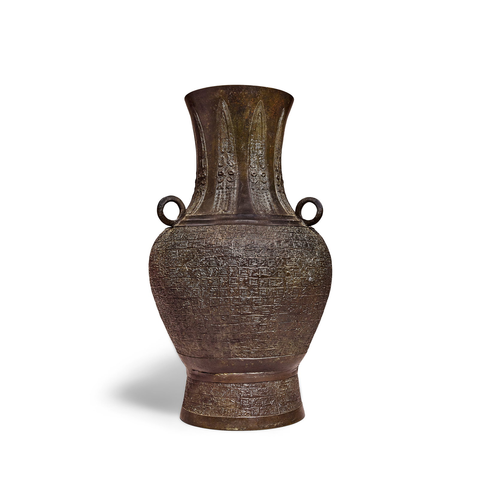 AN ARCHAISTIC BRONZE VASE, HU 17th/18th century: AN ARCHAISTIC BRONZE VASE, HU 17th/18th century Of baluster form, set on a gently flared foot and with tall flaring neck, set with three ring handles to the ribbed shoulder, the body and foot cast in 