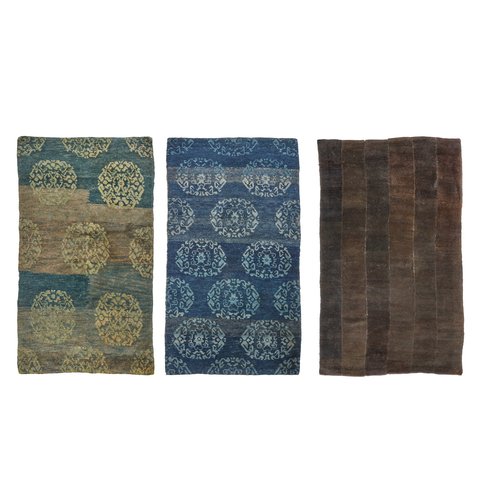 THREE WOOL KHADEN RUGS Tibet, 19th century: THREE WOOL KHADEN RUGS Tibet, 19th century Comprising two indigo rugs with stylised peony roundels and a grey-brown rug composed of longitudinal panels. The largest 178cm (70 1/8in) high x 88cm (34 5/