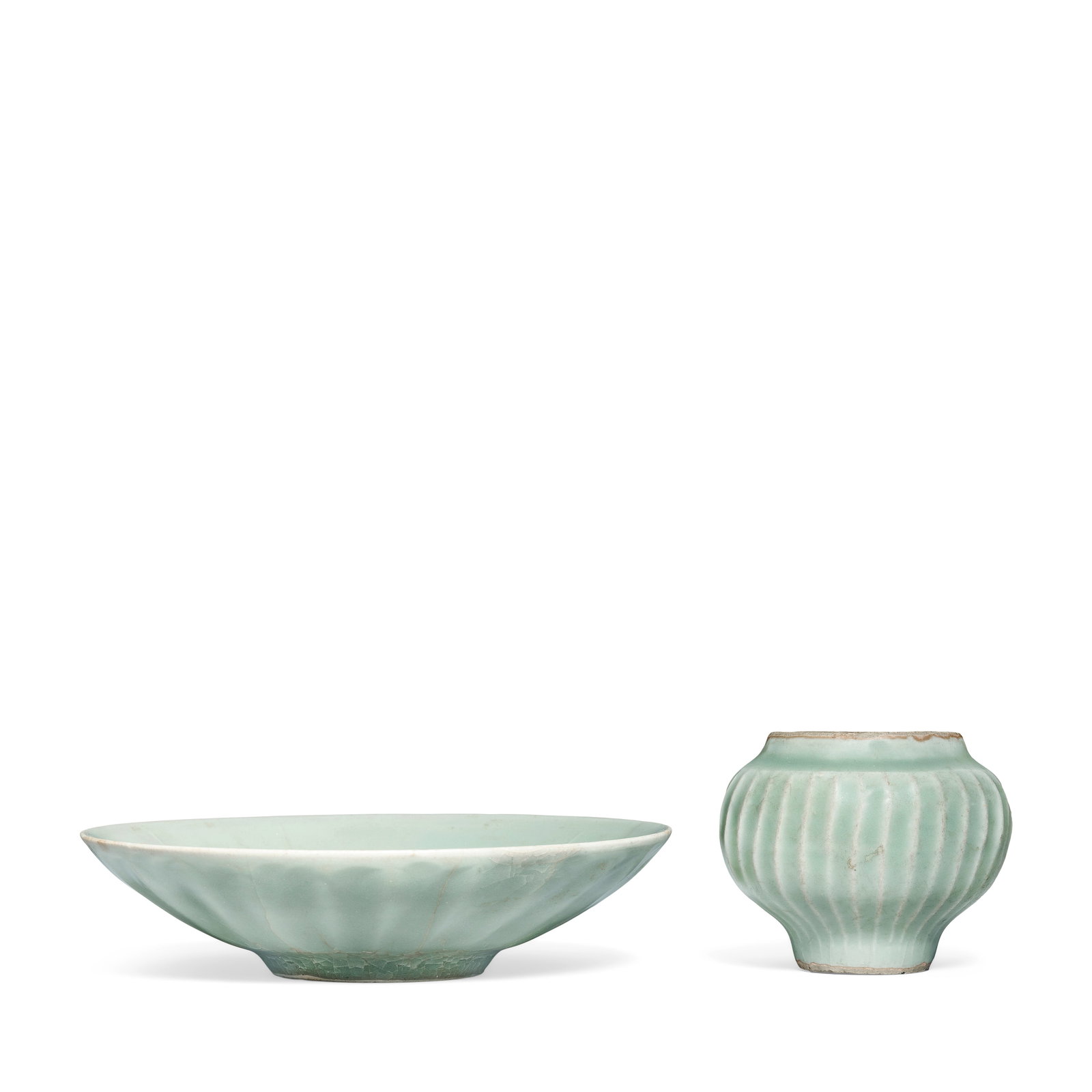 A LONGQUAN CELADON DISH AND SMALL RIBBED JAR Song Dynasty (2): A LONGQUAN CELADON DISH AND SMALL RIBBED JAR Song Dynasty The dish with gently flaring sides, carved to the exterior with a band of ribbed petals; the jar of rounded form tapering towards the foot, de
