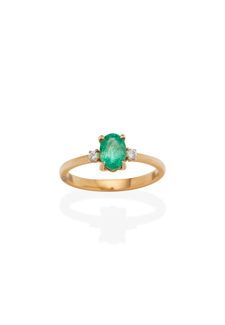 EMERALD AND DIAMOND RING: EMERALD AND DIAMOND RING - oval shaped emerald weighing approximately 0.60cts - 2 round brilliant-cut diamonds - stamped 750 - weight 2.3gm - ring size M Footnotes: OVERALL CONDITION: Metal stamped