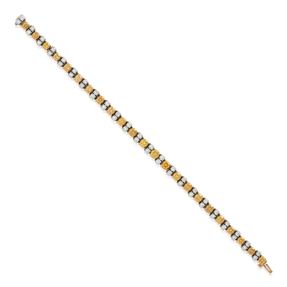 OSCAR HEYMAN: A COLORED DIAMOND AND DIAMOND BRACELET: OSCAR HEYMAN: A COLORED DIAMOND AND DIAMOND BRACELET Set with twenty-three full-cut colored diamonds, and diamonds, total weight 8.64 carats, in platinum and 18k gold, weight 14.5 dwt, maker's mark fo