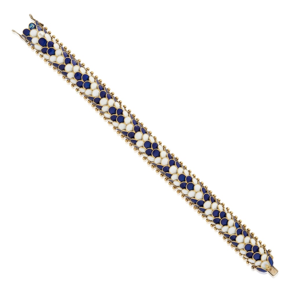 AN 18K GOLD AND ENAMEL BRACELET, ITALY: AN 18K GOLD AND ENAMEL BRACELET, ITALY The bombé form composed of scale links in blue and white enamel, weight 48.4 dwt, length 6 7/8 in. For further information on this lot please visit Bonhams.