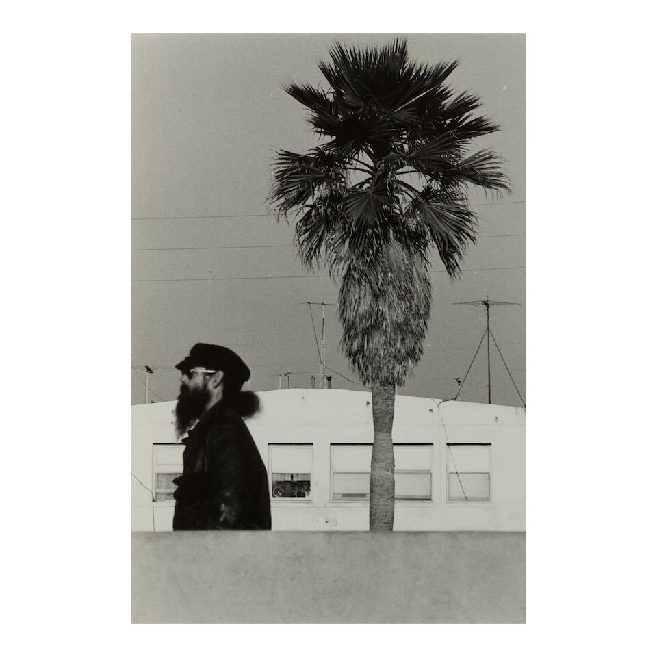 Elliott Erwitt (1928-2023); Bearded Man with Tree, Venice, U.S.A.;: Elliott Erwitt (1928-2023) Bearded Man with Tree, Venice, U.S.A., 1976 Gelatin silver print; signed in pencil on the reverse, framed. 11 7/8 x 7 7/8 in. (30.1 x 20.0 cm) sheet 13 7/8 x 10 7/8 in. (35.