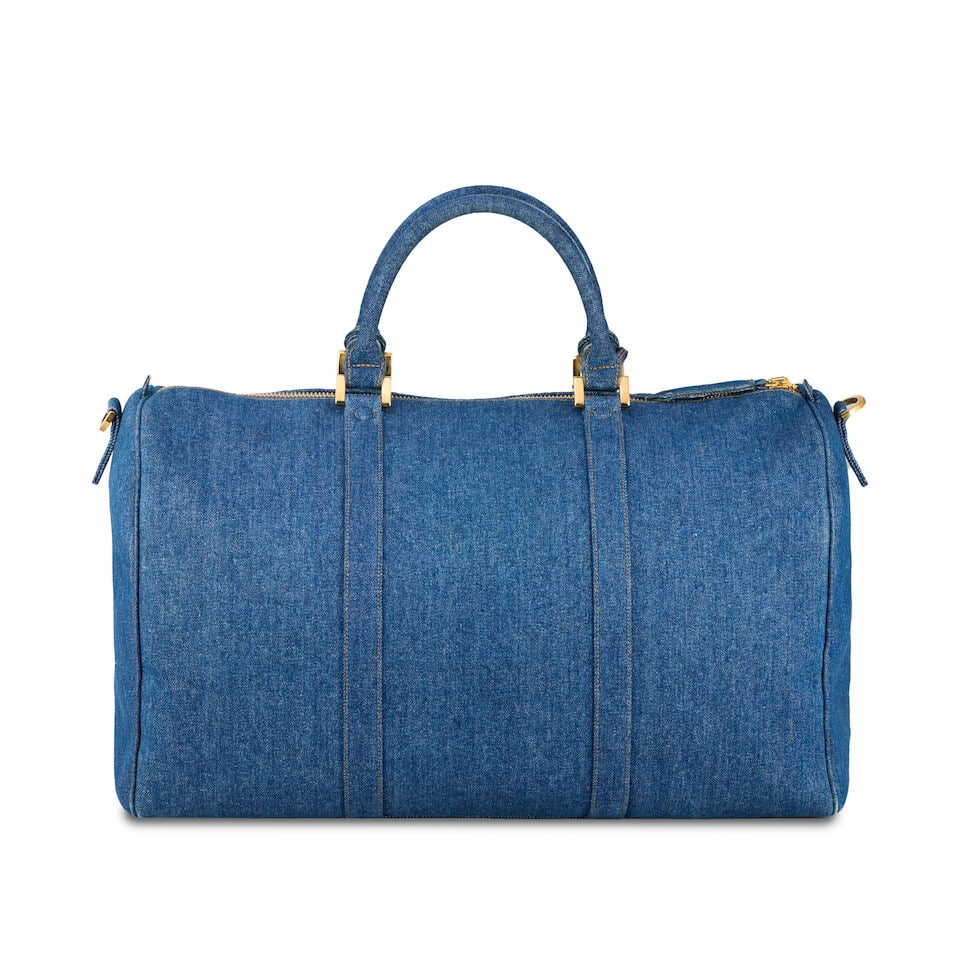 Chanel: a Denim 2-Way Boston Bag 1997 (includes serial sticker, authenticity card, keys, padlock...: Chanel: a Denim 2-Way Boston Bag 1997 Creative Director: Karl Lagerfeld Blue denim travel bag with yellow stitching, CC design to one side, gold tone hardware Condition Grade B 48cm wide, 30cm high, 2