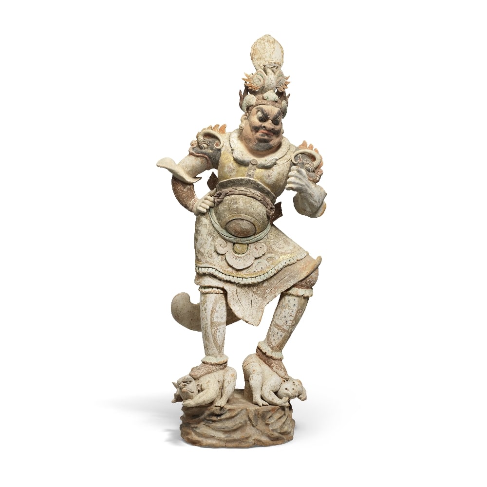 A SUPERB LARGE PAINTED POTTERY FIGURE OF A GUARDIAN Tang Dynasty: A SUPERB LARGE PAINTED POTTERY FIGURE OF A GUARDIAN Tang Dynasty The powerful guardian figure of a lokapala bearing a fearsome expression beneath an elaborate helmet supporting a large phoenix, the st