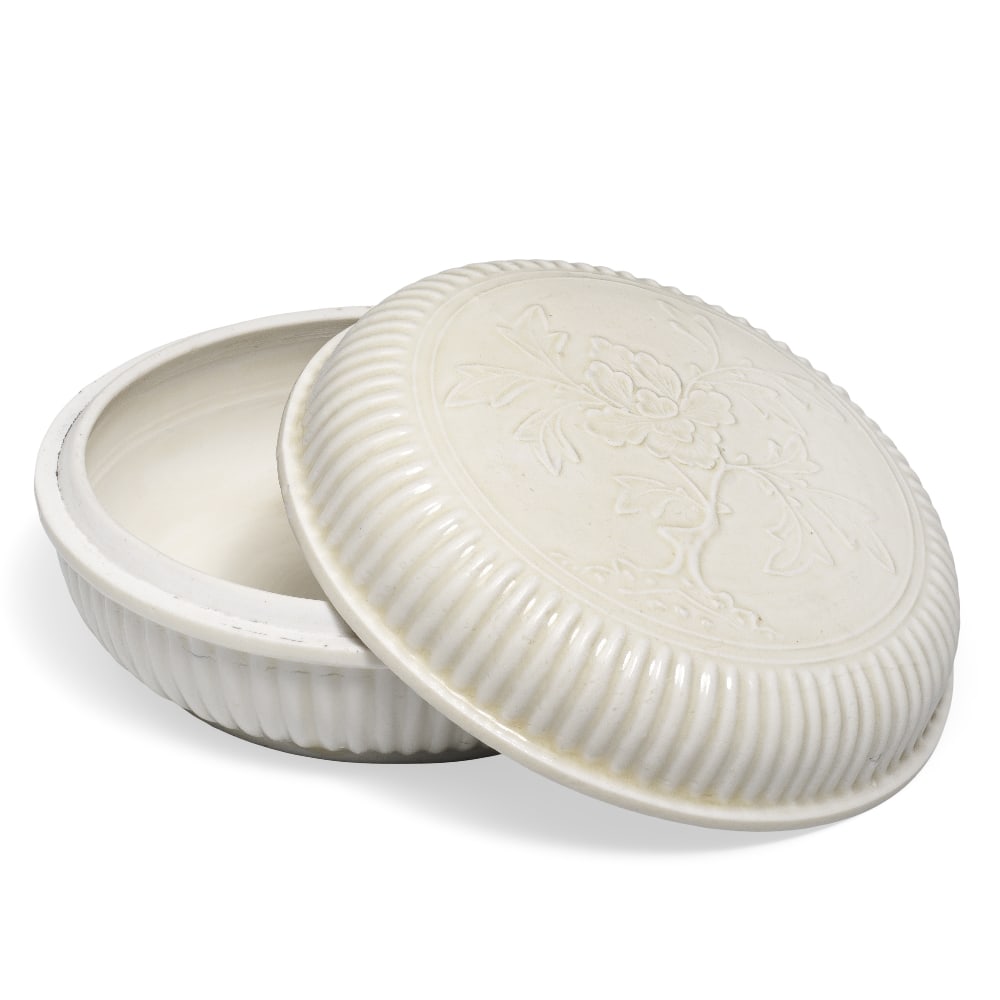 A BLANC-DE-CHINE CIRCULAR 'PEONY' BOX AND COVER 17th century (3): A BLANC-DE-CHINE CIRCULAR 'PEONY' BOX AND COVER 17th century Finley potted with fluted rounded sides rising from a short flat base to a lipped rim, the domed cover similarly with fluted sides, the cen