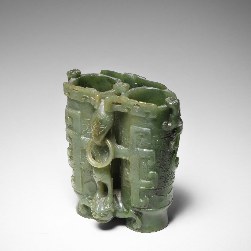 A SPINACH-GREEN JADE CARVED 'CHAMPION' VASE Signed Zigang, 18th/19th century (2): A SPINACH-GREEN JADE CARVED 'CHAMPION' VASE Signed Zigang, 18th/19th century Carved in the form of two tubular vases, joined by a rectangular section incised with a two-character inscription reading z