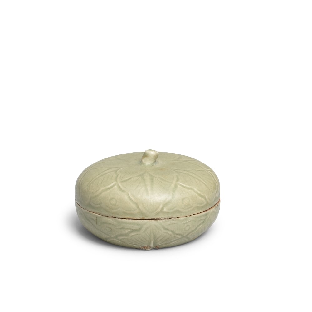 A YUEYAO CELADON 'PERSIMMON' COSMETIC BOX AND COVER Five Dynasties Period (2): A YUEYAO CELADON 'PERSIMMON' COSMETIC BOX AND COVER Five Dynasties Period The slightly domed cover with a 'twig' finial surrounded by finely carved overlapping leaves with finely incised veins, the gr