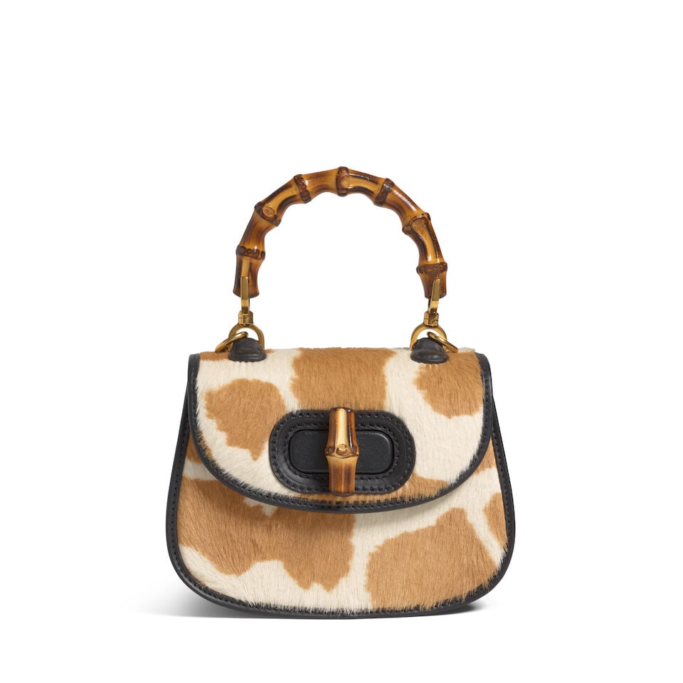 GUCCI: GIRAFFE PRINT PONY HAIR MINI BAMBOO 1947 Spring/Summer 2022: GUCCI: GIRAFFE PRINT PONY HAIR MINI BAMBOO 1947 Spring/Summer 2022 • Neutral Giraffe Print Pony Hair and Black Leather Trim Exterior • Gold Tone Hardware • Bamboo Top