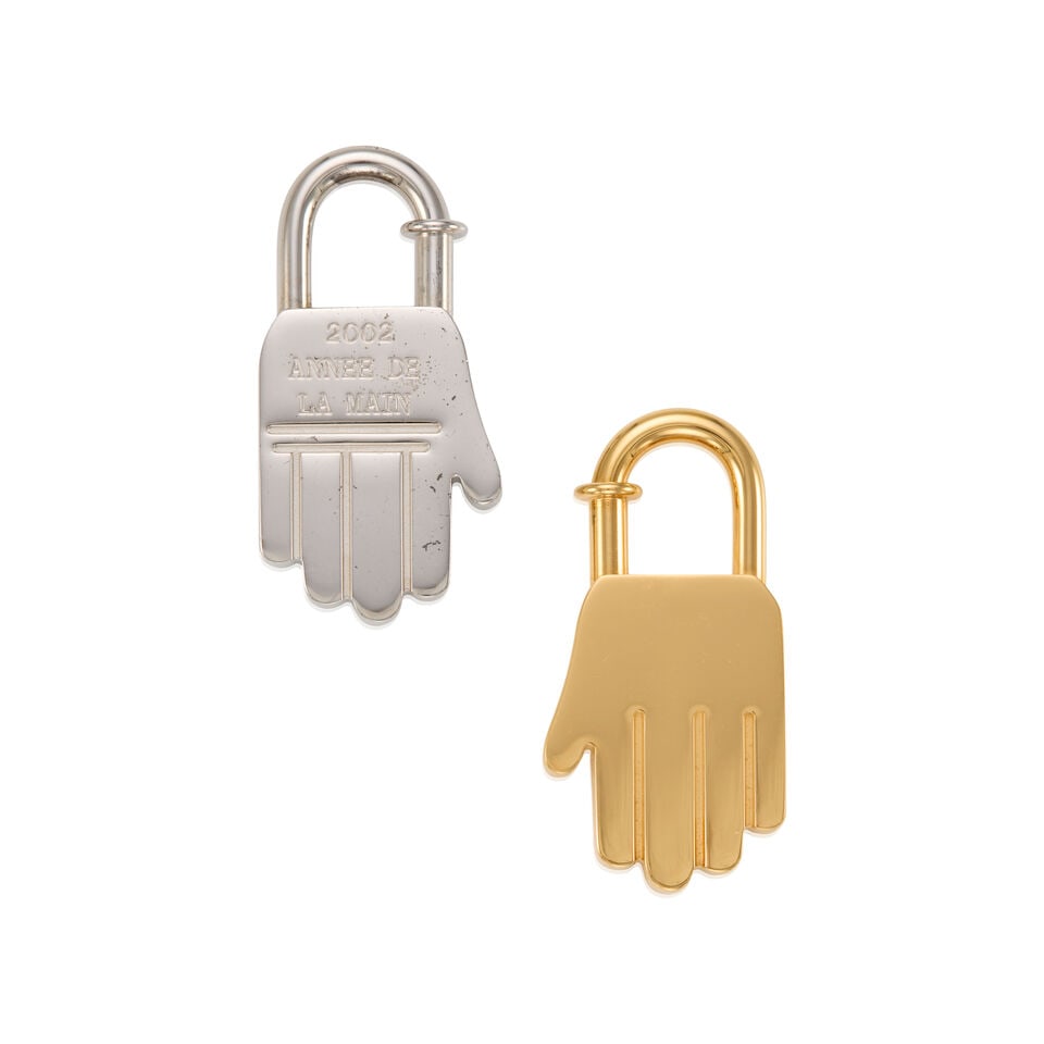 HERMÈS: A SET OF TWO HAND CADENA LOCK CHARMS 2002: HERMÈS: A SET OF TWO HAND CADENA LOCK CHARMS 2002 • Gold-Plated and Palladium Hardware • Spring-Loaded Push Lock Closure • 'HERMÈS Annee De La Main 2002' Inscribed at Back