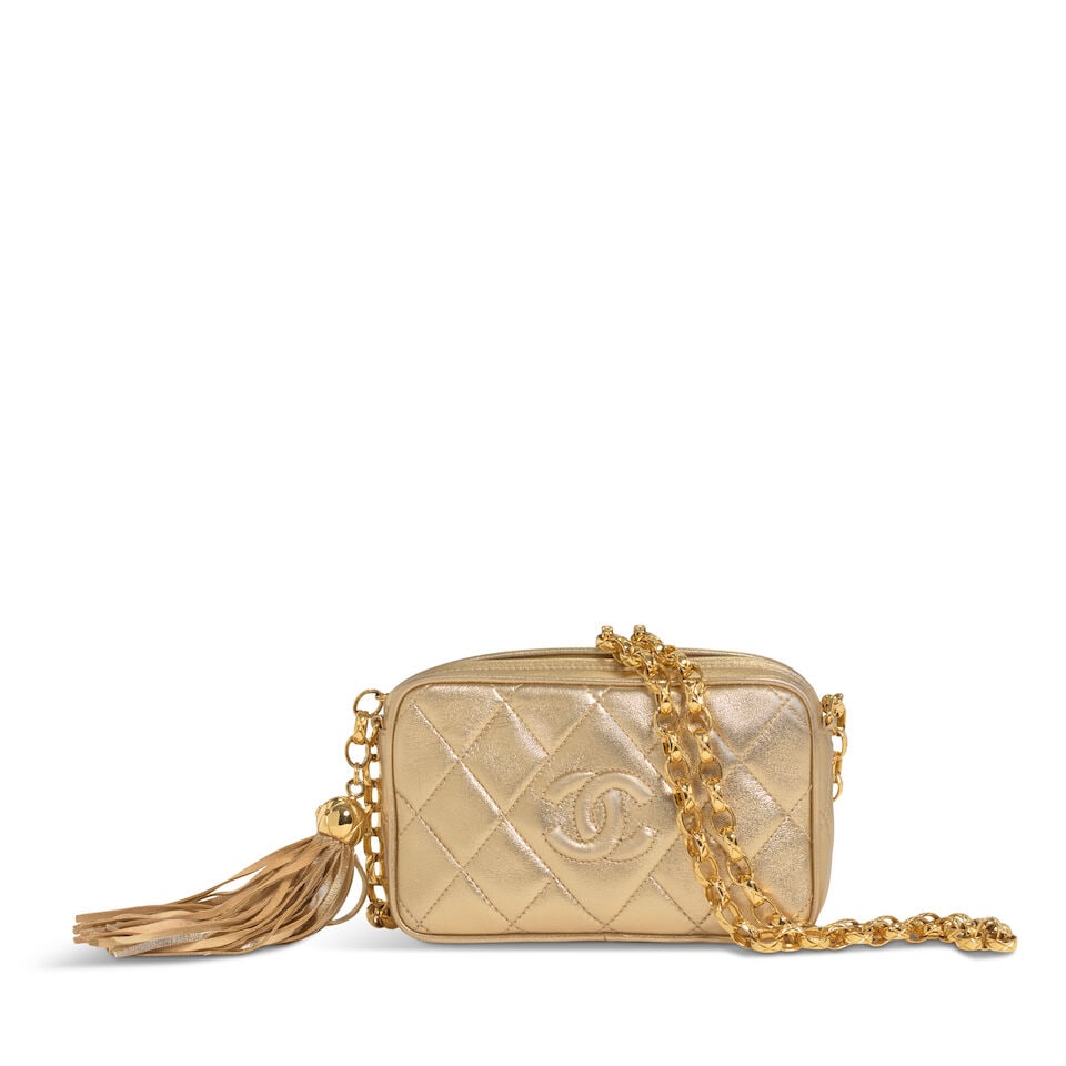 CHANEL: GOLD QUILTED LAMBSKIN CC MINI CAMERA BAG 1994-1996: CHANEL: GOLD QUILTED LAMBSKIN CC MINI CAMERA BAG 1994-1996 • Gold Lambskin Quilted Exterior • Gold Tone Hardware • Zip Closure with Tassel Detail • Bijoux Chain Shoulder Strap 