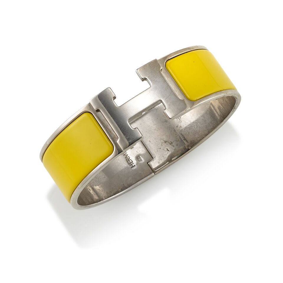 HERMÈS: YELLOW ENAMEL CLIC CLAC H BRACELET: HERMÈS: YELLOW ENAMEL CLIC CLAC H BRACELET • Palladium Plated Hardware with Yellow Enamel Inlay • Measures 6.5 cm Diameter x 2 cm Width For further information on this lot please