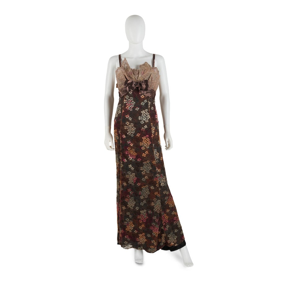 CHRISTIAN LACROIX: GOLD AND MULTICOLOR LACE EVENING GOWN Fall 1995: CHRISTIAN LACROIX: GOLD AND MULTICOLOR LACE EVENING GOWN Fall 1995 • Marked Size 42 • Gold and Multicolor Lace Exterior with Bow Detail at Bust • Black Silk Blend Interior