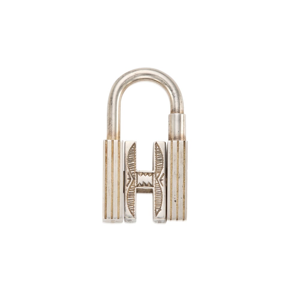 HERMÈS: SILVER TOUAREG ROTATING H CADENA LOCK CHARM: HERMÈS: SILVER TOUAREG ROTATING H CADENA LOCK CHARM • Sterling Silver Hardware • Rotating Center H • Screw Closure • 925 Marking Inscribed at Base • Measures 4 cm x 