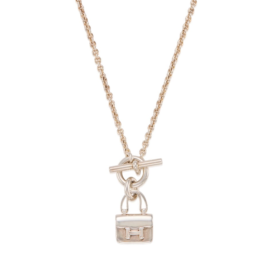 HERMÈS: SILVER MINI CONSTANCE AMULETTE PENDANT NECKLACE 2022: HERMÈS: SILVER MINI CONSTANCE AMULETTE PENDANT NECKLACE 2022 • Marked 925 Sterling Silver • Toggle Clasp Closure • Box Included • Chain Drop 20 cm | Pendant 1 cm x 1 cm Fo