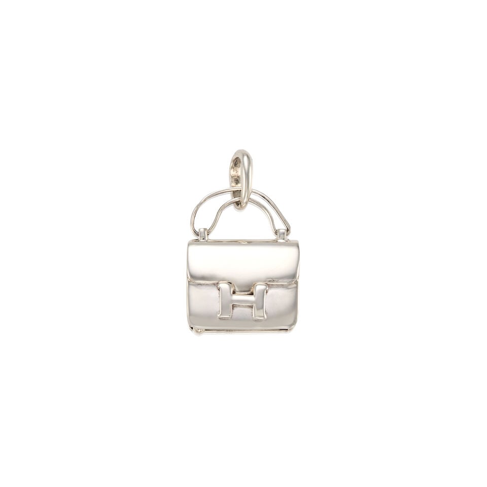 HERMÈS: SILVER CONSTANCE PILL BOX CHARM: HERMÈS: SILVER CONSTANCE PILL BOX CHARM • Marked Sterling Silver • Slide Base Opening • Closed Jump Ring for Chain Addition • Measures 2 cm x 2.5 cm For further informatio