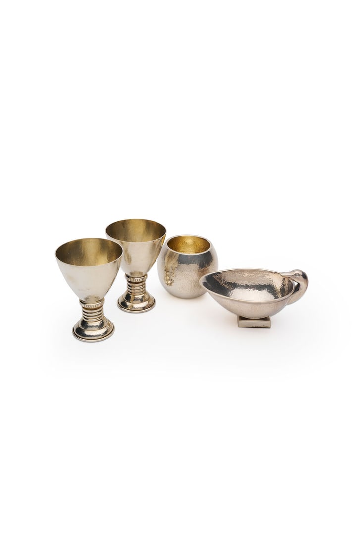 Ilias Lalaounis | group of sterling silver objects (4): Ilias Lalaounis | group of sterling silver objects Comprising a pair of cups, measuring 10.5 x 7.5cm; Sauce boat, measuring 7.5 x 14.0cm; Bowl, height 7.0cm, each signed Ilias LALAoUNIS, numbered