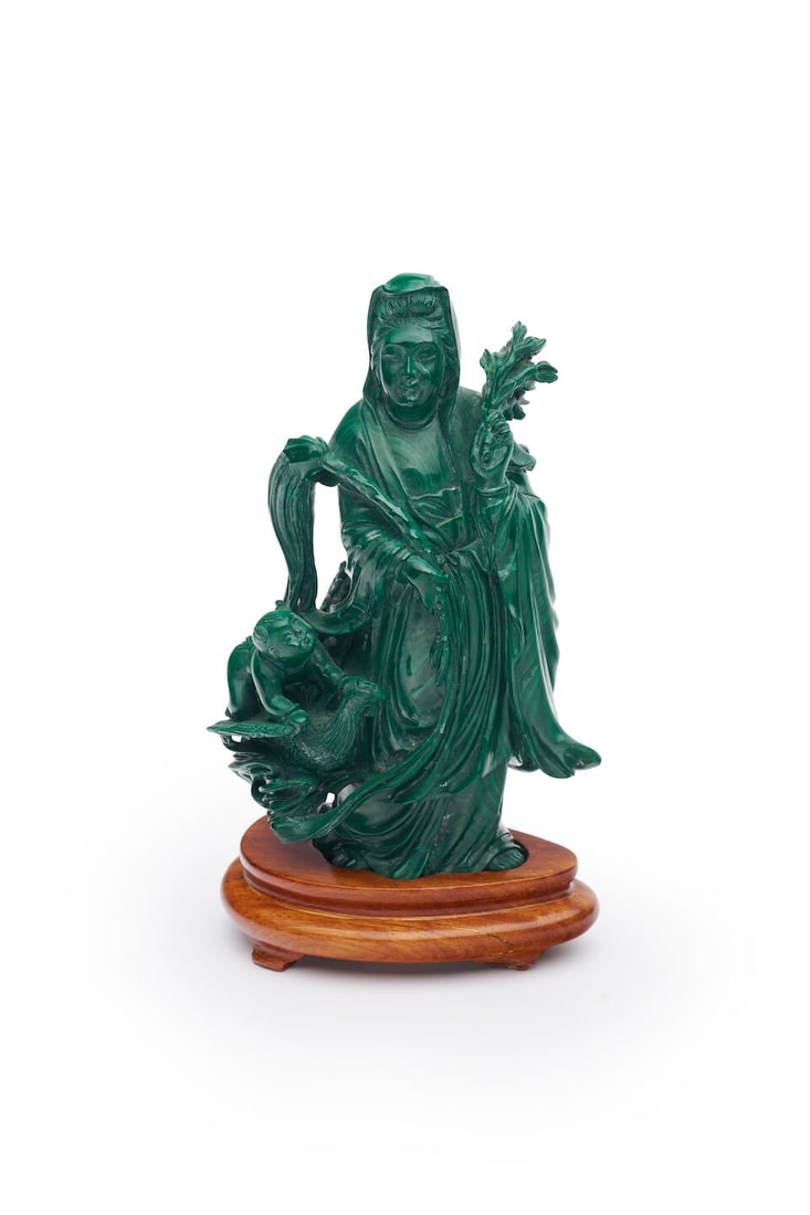 Malachite figure of Guanyin and hardstone vase and cover (2): Malachite figure of Guanyin and hardstone vase and cover Both on wooden stand, Height both 17.5cm not including stand. (2) For further information on this lot please visit Bonhams.com For further