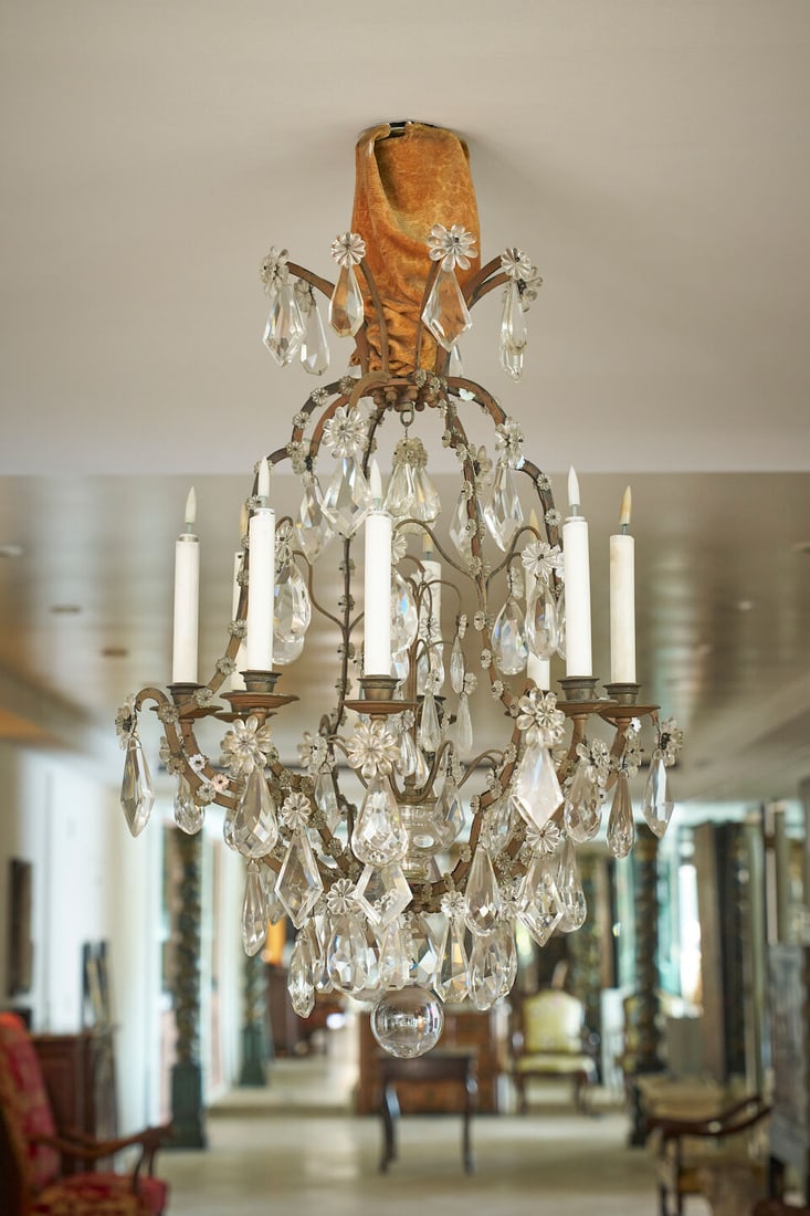 A Louis XV style bronze and cut-crystal chandelier French, 19th century: A Louis XV style bronze and cut-crystal chandelier French, 19th century Of bird cage form with eight-lights, the scrolling arms hung with floral, diamond and pear-shaped drops, with a large ball
