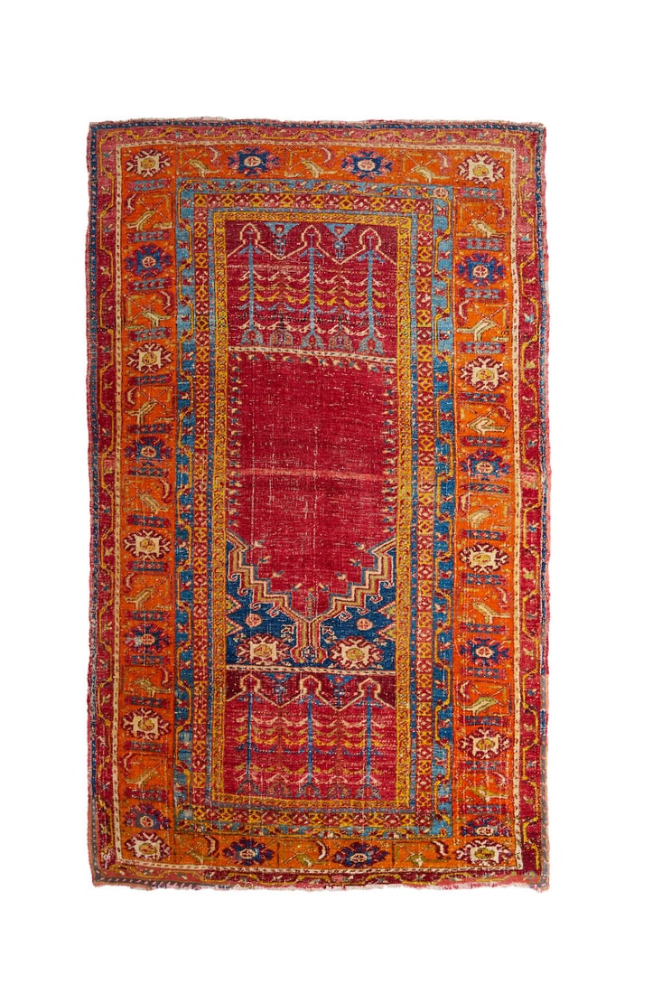 A prayer rug,: A prayer rug, in warm tones of orange, burgundy and blue, worn with losses to the margins, 183.0 x 112.0cm This lot is subject to the following lot symbols: TP TP Please note this lot is available for