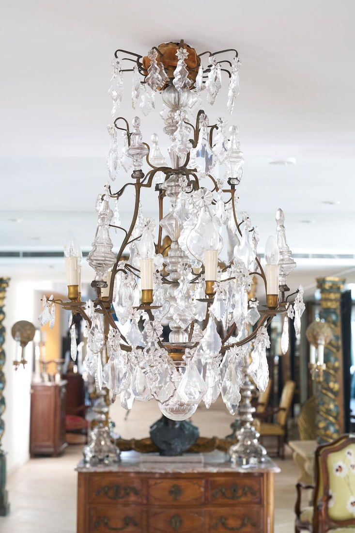 A Louis XV style nine-light gilt metal and cut-glass chandelier, 19th century,: A Louis XV style nine-light gilt metal and cut-glass chandelier, 19th century, Of bird cage form with central blown-glass stem, the scrolling arms hung with floral and pear-shaped drops, with a large