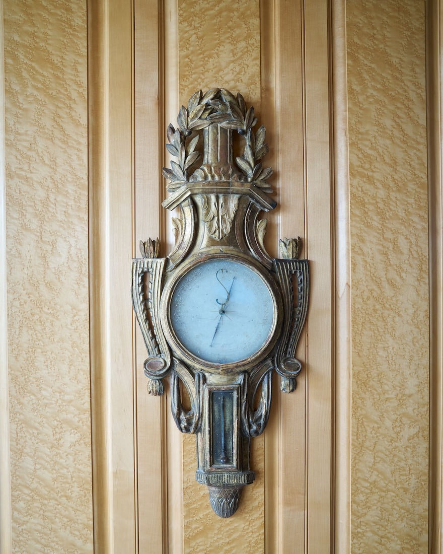 A late 18th century French carved giltwood mercury barometer: A late 18th century French carved giltwood mercury barometer The case carved with a reeded column flanked by a pair of laurel wreaths over swept sides to a draped lower section containing the coloured