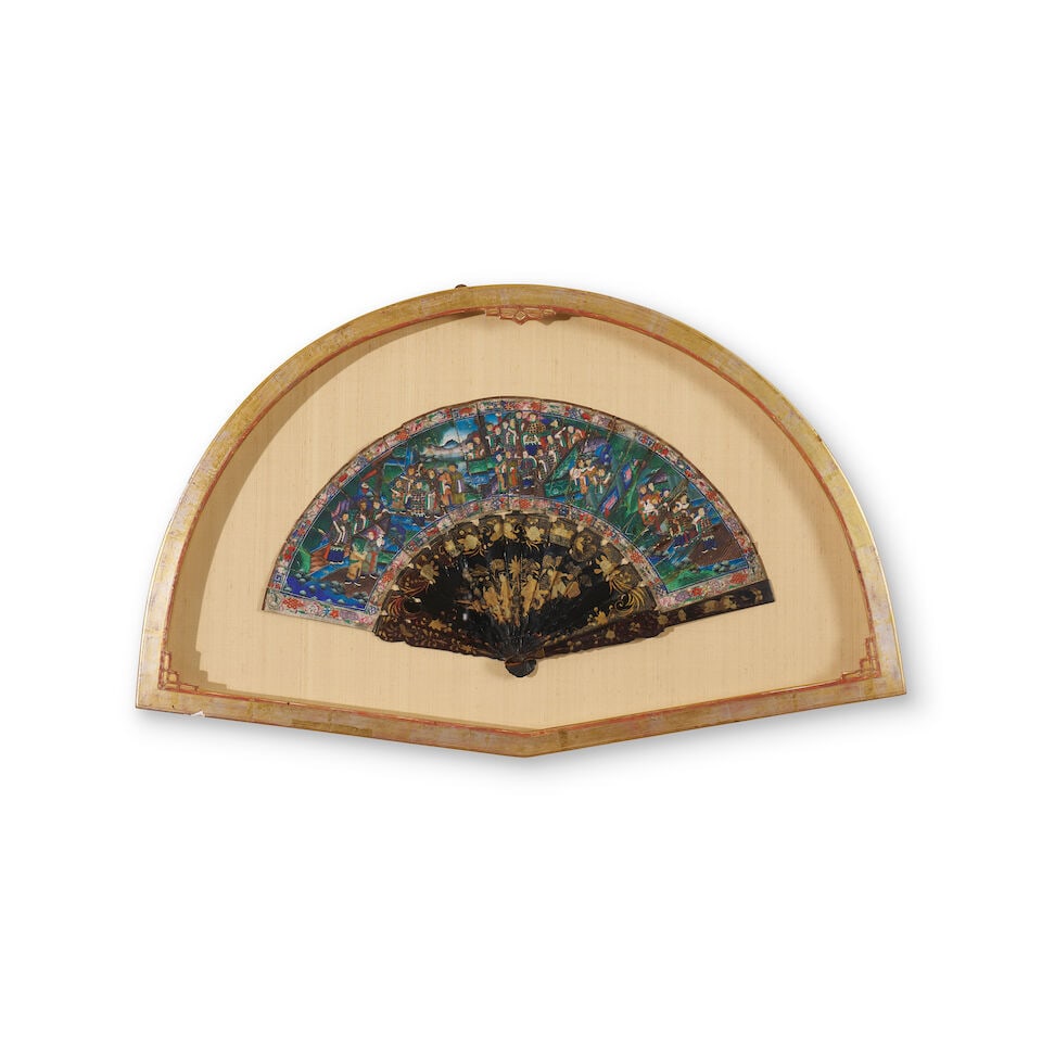 An export painted and lacquered folding fan Canton, China, 19th century: An export painted and lacquered folding fan Canton, China, 19th century decorated with figural court scenes and floral borders on the leaf, and gilt lacquer work on the guards, displayed open in a