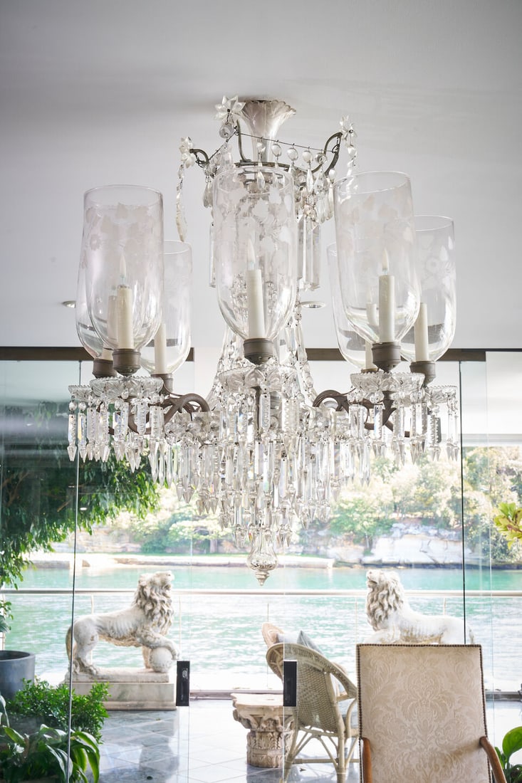 A tiered crystal lustre eight-light chandelier, possibly French, 20th century: A tiered crystal lustre eight-light chandelier, possibly French, 20th century With upswept branches supporting etched glass hurricane shades, wired for electricity, 93.0 cm drop. This lot is subject t