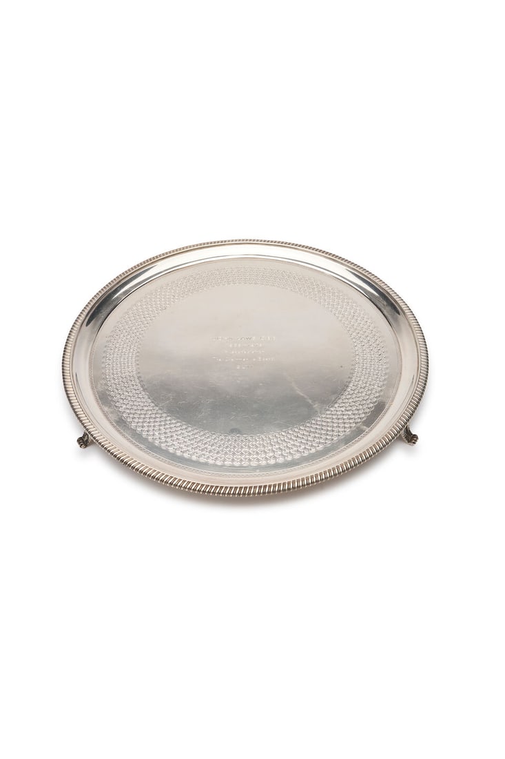 A George III English silver salver Peter & William Bateman, London, 1807: A George III English silver salver Peter & William Bateman, London, 1807 gadrooned border, raised on three scroll feet, the centre engraved 'JOHN LAWS C.B.E. / 1969 - 1979 / In appreciation / The Chai
