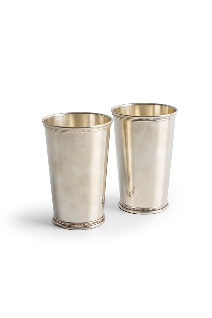 Tiffany & Co. | sterling silver beakers, New York, 20th century (2): Tiffany & Co. | sterling silver beakers, New York, 20th century each with beaded detail to rim and foot, both engraved with dedications to the base from Caroline to John Laws, weight 295.0gms. (2) For