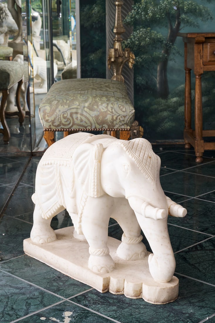 A pair of elephant sculptures, India,: A pair of elephant sculptures, India, in white marble, each with vertical post holes to their middle backs, on integral bases, height: 48.0cm, width: 25.5cm, depth: 67.0cm This lot is subject to the
